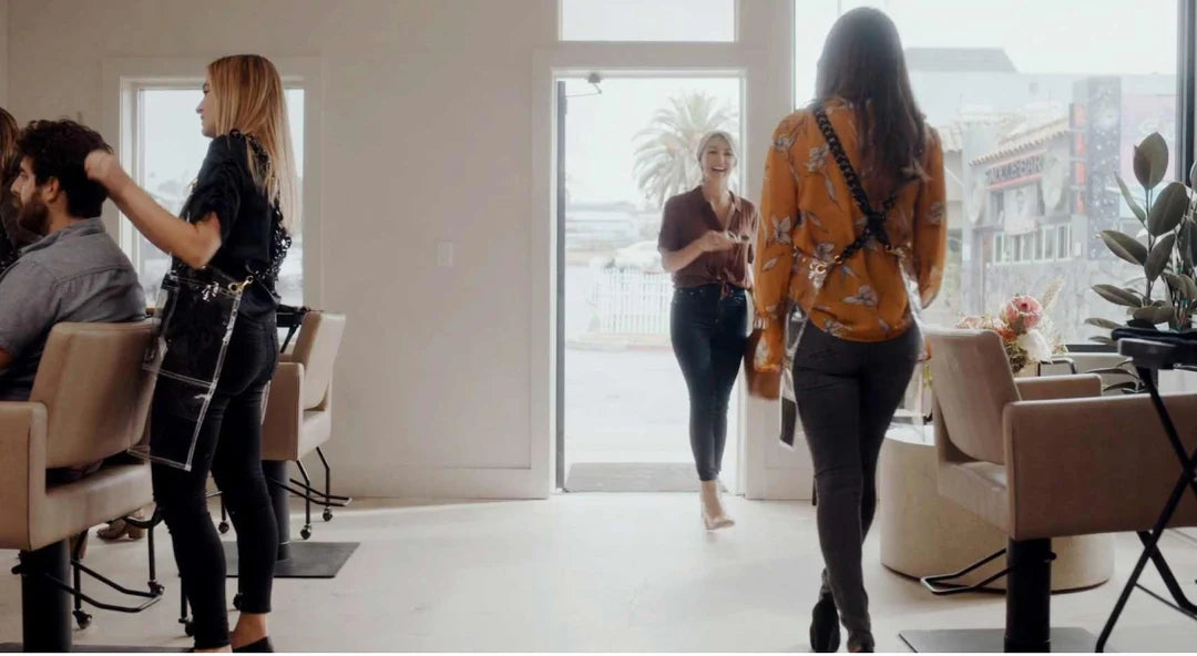 A stylist welcoming clients into a bright salon
